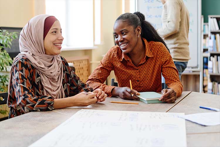 

  
      Women in a classroom setting talking.
  
